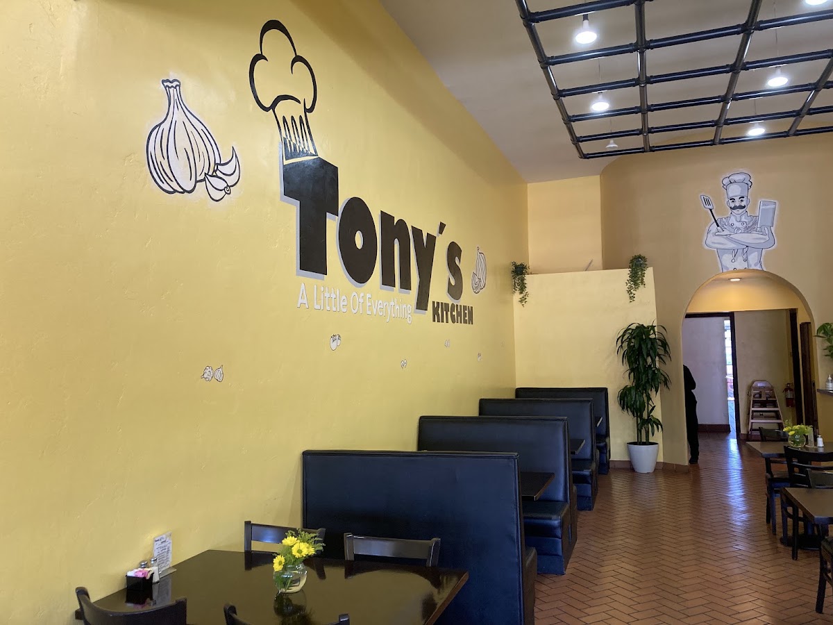 The front dining room with the Tony's Kitchen name hand painted across the yellow wall above the booths
