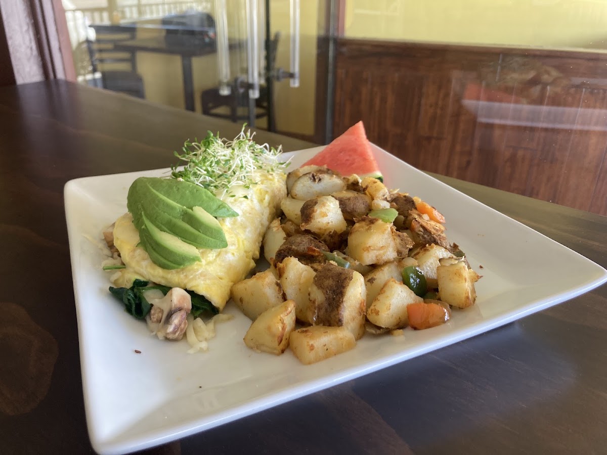 Veggie omelette with avocado and sprouts, home fries and watermelon