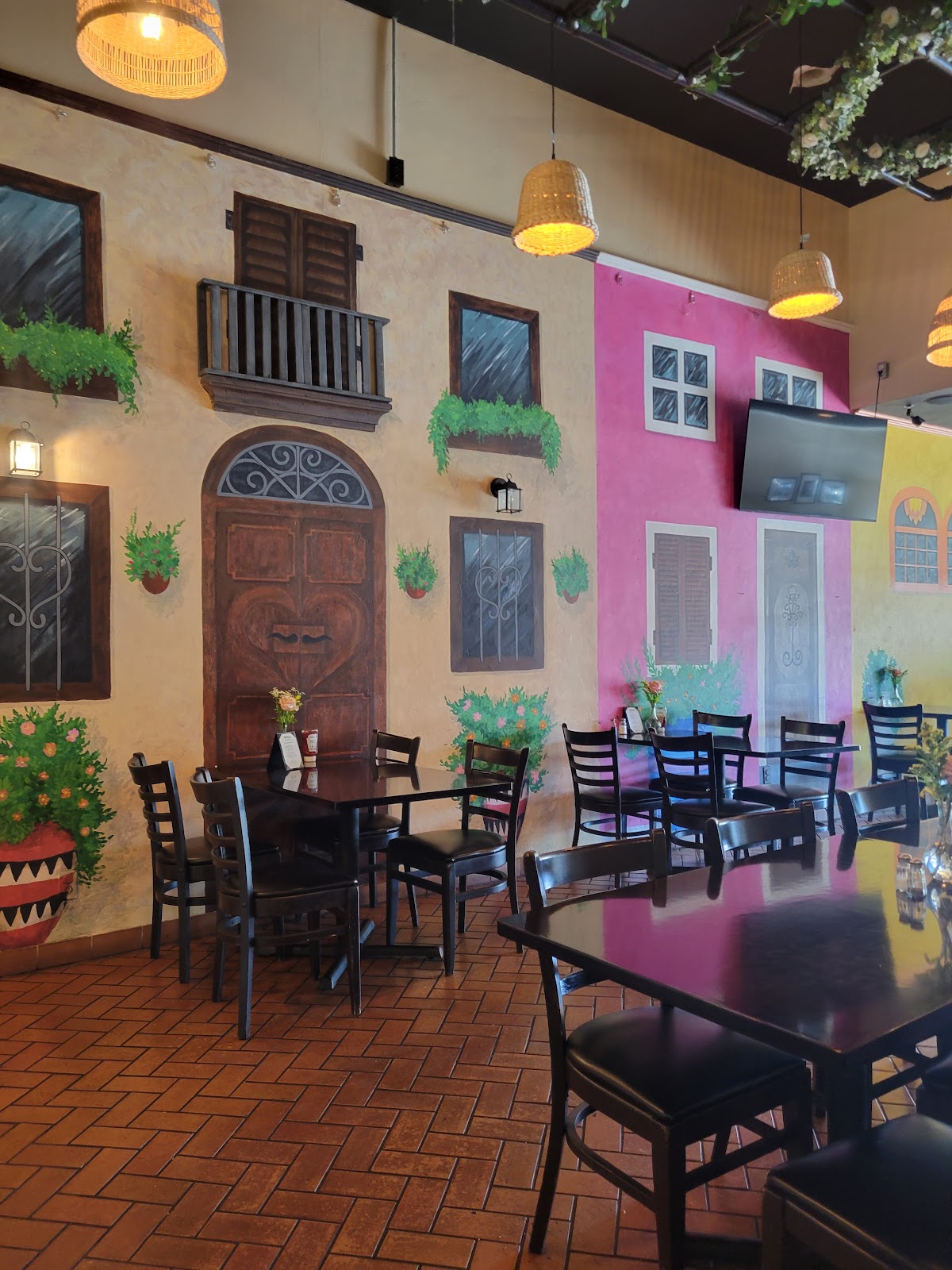 The back dining room at Tony's Kitchen, with a painted streetscape mural of balconies, shuttered windows and flower pots
